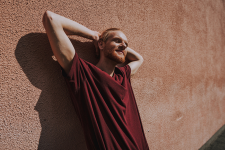 Young relaxed hipster man leaning on buildingの写真素材