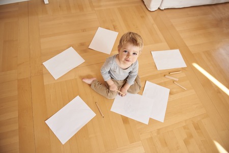 Cute little boy drawing with pencil at homeの写真素材