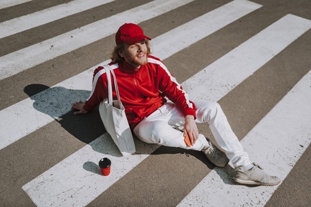 Happy hipster man relaxing on road crosswalkの写真素材
