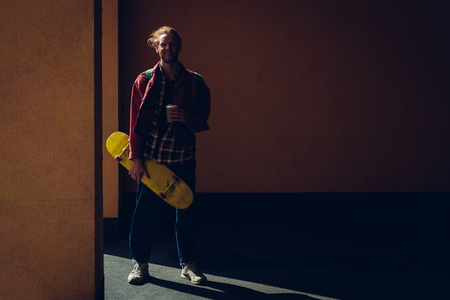 Skater man with cup of coffee and skateboardの写真素材
