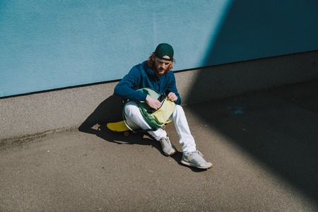 Skater man looking for something in sackの写真素材