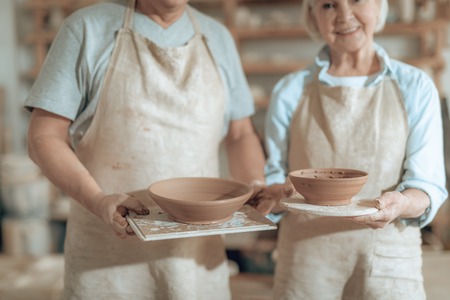 Close up of ceramic bowls situating in potters armsの写真素材