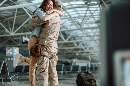 Low angle of happy young couple hugging each other in big hallの写真素材