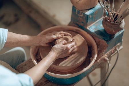 Cropped photo of female hands with clay in workshopの写真素材