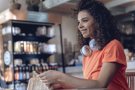 Smiling woman with gadget is spending time in cafeの写真素材