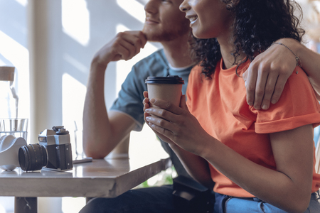 Relaxed couple with vintage camera is enjoying coffee indoorsの写真素材