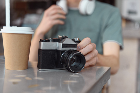 Male with retro camera and hot drink indoorsの写真素材