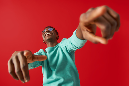 Smiling guy in glasses is making dance moves in studioの写真素材