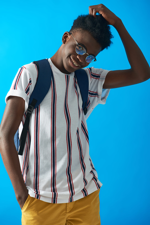 Happy African American guy is staying with backpackの写真素材