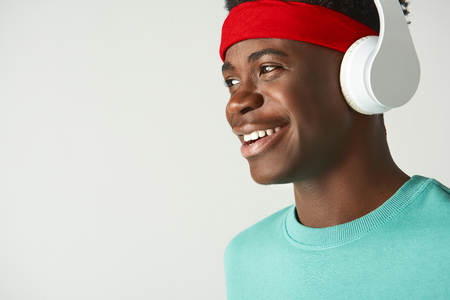 Happy Afro American guy standing with headphonesの写真素材