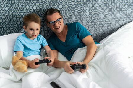 Father in glasses and son playing the console