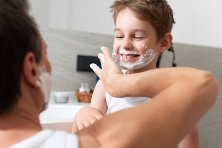 Father and happy son having fun and shavingの写真素材
