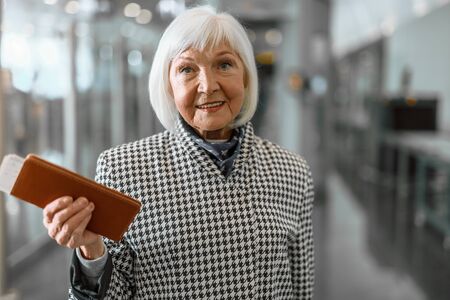 Smiling senior woman is staying at airportの写真素材