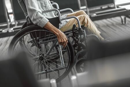 Elderly lady is using a wheelchair in front of the windowの写真素材