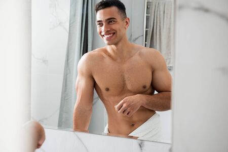 Muscular happy man looking at his reflectionの写真素材