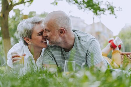 Happy gray-haired male and female in the park togetherの写真素材
