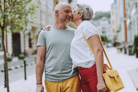 Happy adult gray-haired couple is staying outdoorsの写真素材