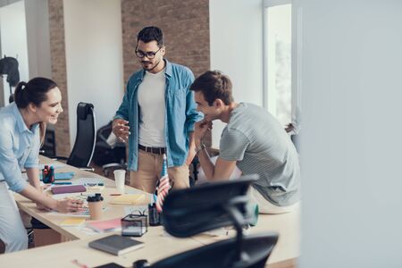 Smiling young coworkers are having discussion project