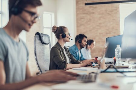 Happy young lady with headset is working in the call centerの写真素材