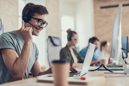 Happy guy in glasses is working in the call center