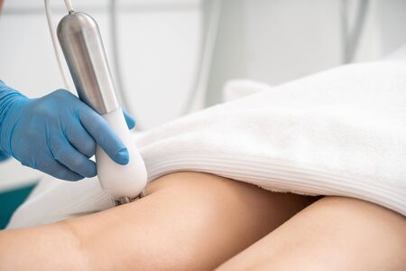 Close up of female legs during roller massage procedure in clinic