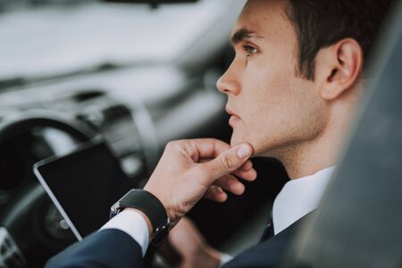 Young man sitting in his auto and looking awayの写真素材