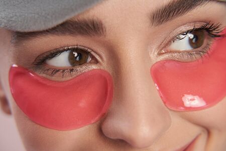Young woman using under-eyes patches to remove puffinessの写真素材