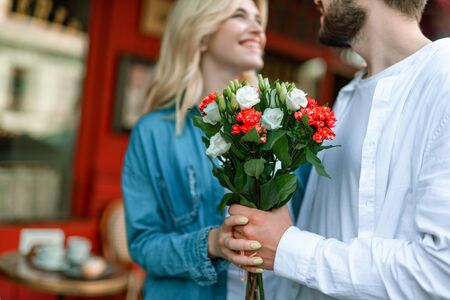Happy woman smiling while cheerful man hugging her outdoorsの写真素材