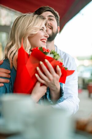 Smiling woman with flowers enjoying the dateの写真素材