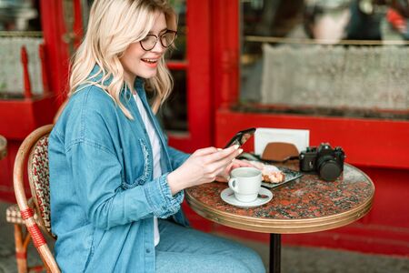 Woman using mobile phone while being in the cafe