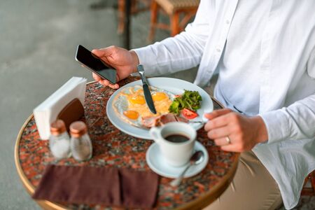 Man using mobile phone while being in the cafeの写真素材