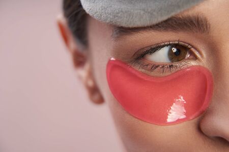 Young lady using under-eyes patches to remove puffinessの写真素材