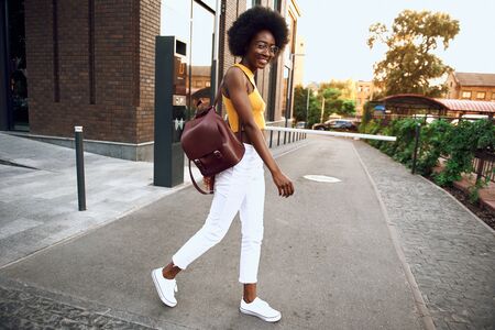 Smiling young woman with bag wearing glassesの写真素材