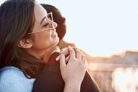 Happy asian lovers hugging on sunset lightの写真素材