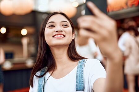 Happy asian lady making selfie on city viewの写真素材