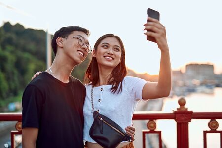 Happy couple making selfie on walking bridgeの写真素材