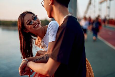 Joyful asian couple meeting on walking bridgeの写真素材