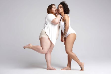 Plus size female friends wearing light swimsuitsの写真素材
