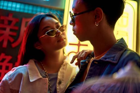 Cool asian couple near entrance of japanese cafeの写真素材