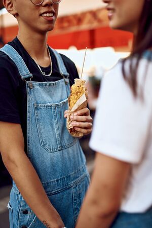 Young asian lovers holding hands on streetの写真素材