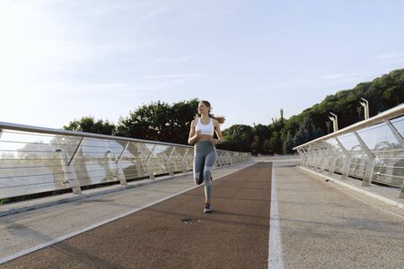 Sportive happy lady on morning training runの写真素材