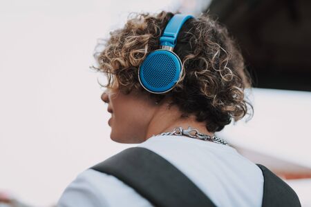 Bright blue headphones on the head of curly manの写真素材