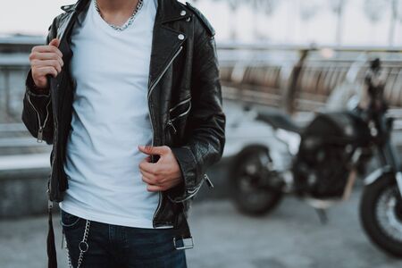 Young biker touching leather jacket on himの写真素材