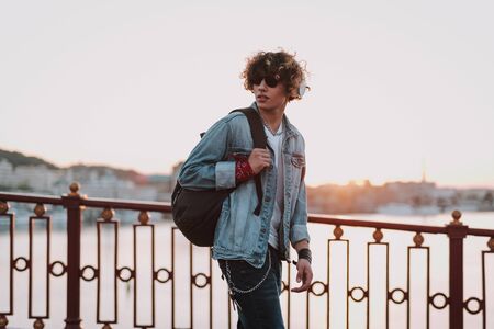 Calm man carrying backpack and walking alone
