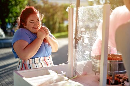 Fat young woman in the city waiting cotton candy