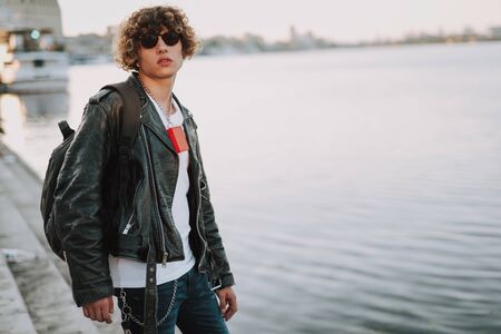 Young biker with backpack next to the riverの写真素材