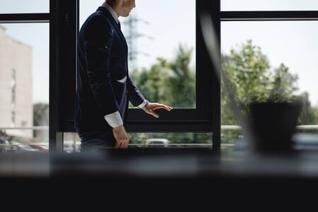 Man touching black window frame in his officeの写真素材