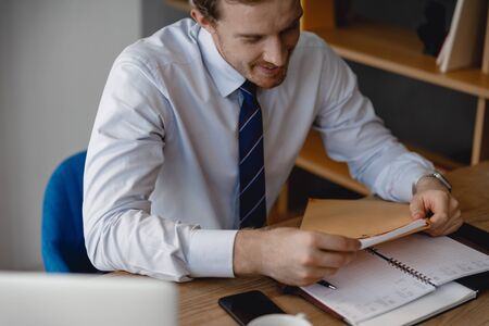 Businessman looking satisfied while taking the documents