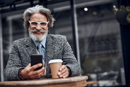 Gladsome man with smartphone laughing stock photoの写真素材
