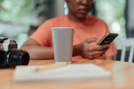 Young african american female with beverage in cafeの写真素材